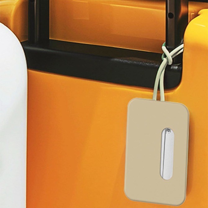 A luggage tag in a soft beige colour attached to the handle of an orange suitcase. It has a logo on the tag.