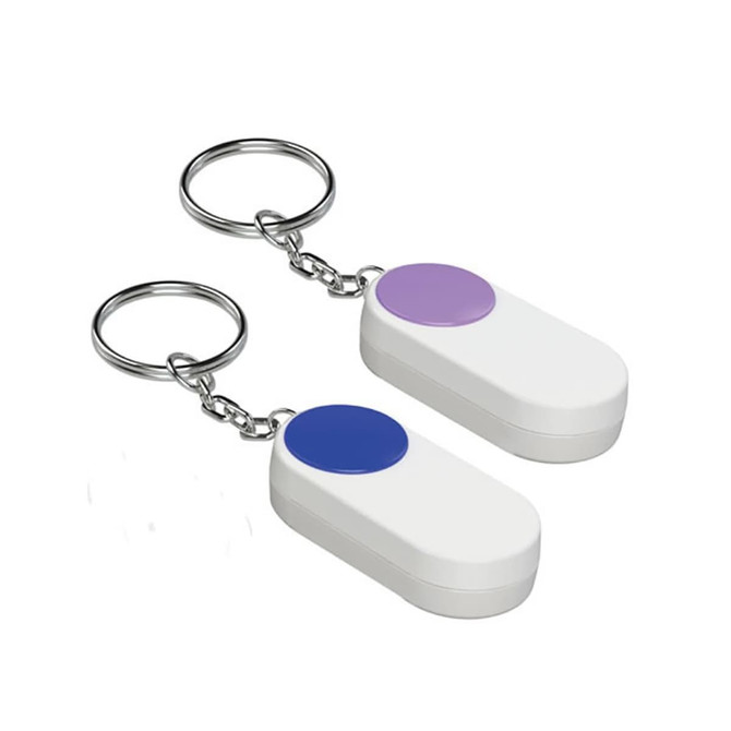 A pair of white pill boxes with coloured buttons, attached to keychain rings.