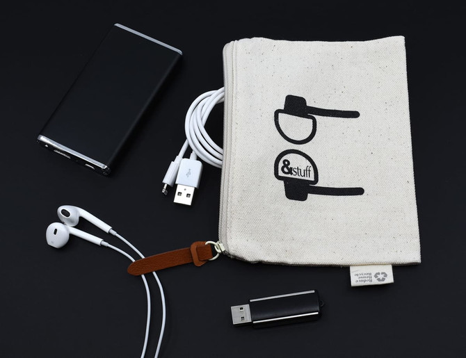 A neutral calico earphone pouch with a logo, surrounded by earphones, USB cables, and a portable charger.