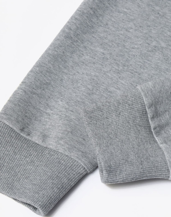 A grey unisex crew neck sweater displayed at an angle, highlighting the cuff detail. The fabric appears soft and textured.