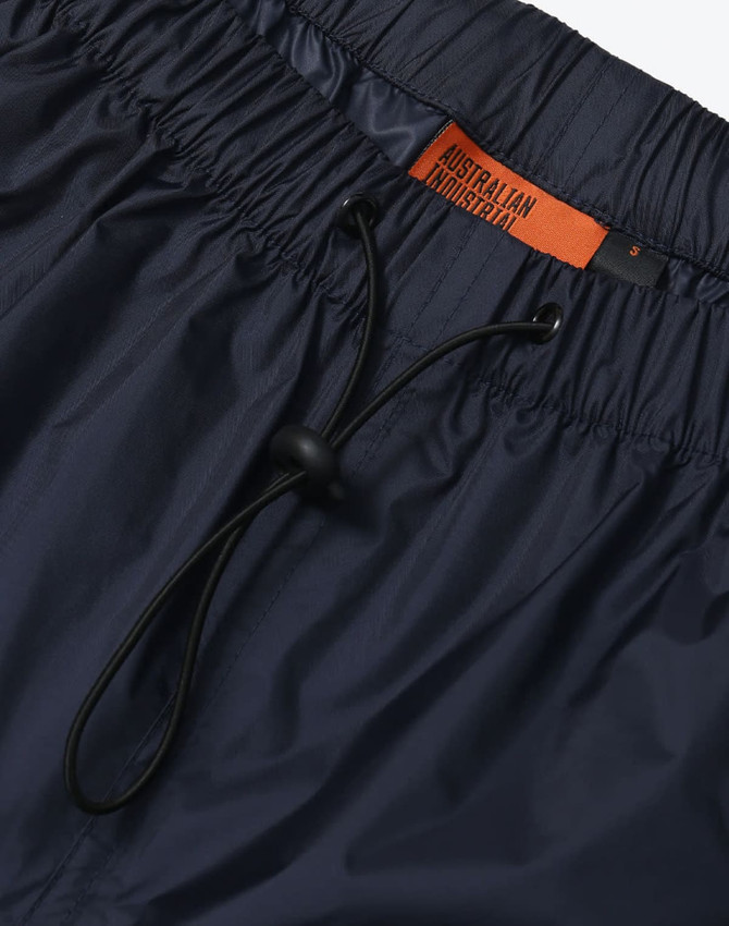 Lightweight nylon waterproof rain pants in navy blue, featuring an elastic waistband and drawstring for adjustment.