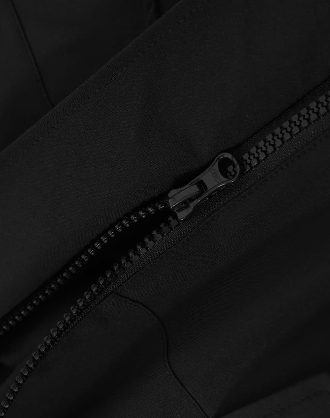 A black quilted waterproof jacket featuring a zipper detail. The fabric appears smooth and durable.