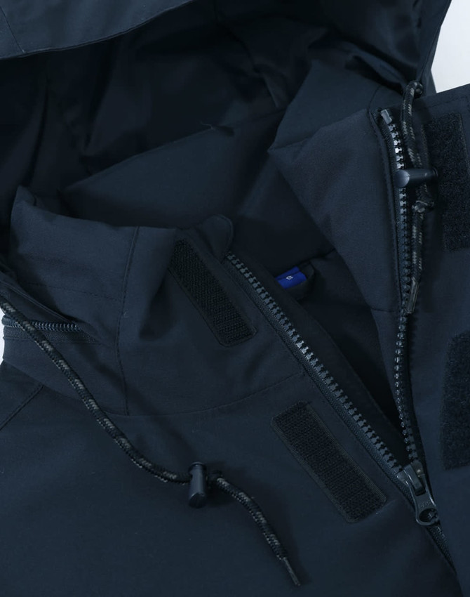 A unisex quilted waterproof jacket in navy, featuring zippers and adjustable toggles. Includes branding details.