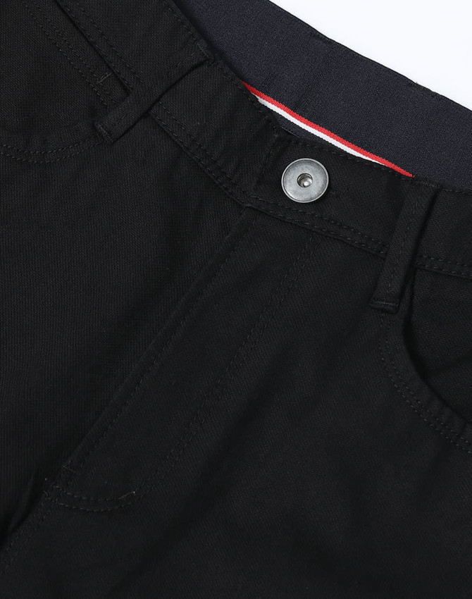 Black flexi chino pants featuring a button closure and pockets, with a subtle brand logo on the waistband.