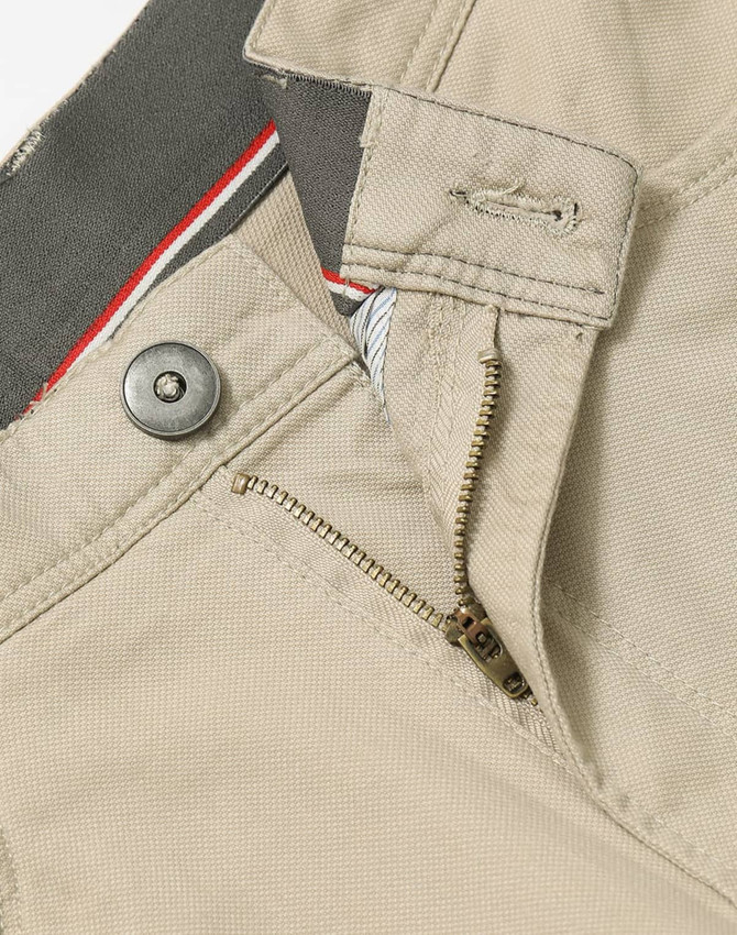 Men's flexi chino pants in beige, featuring a zip fly and button closure, with a logo on the waistband.