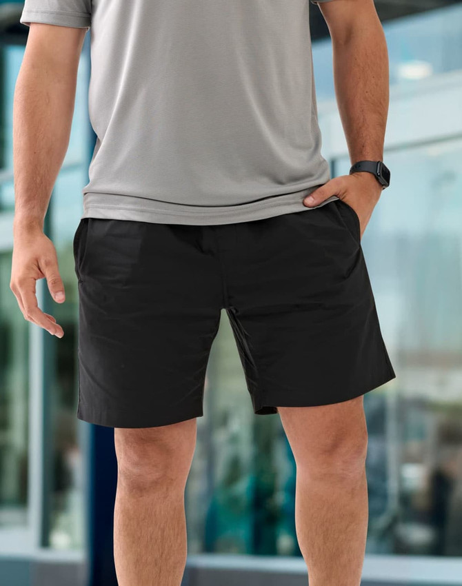 Unisex mercerised cotton shorts in black, featuring side pockets and a comfortable fit, paired with a grey top.