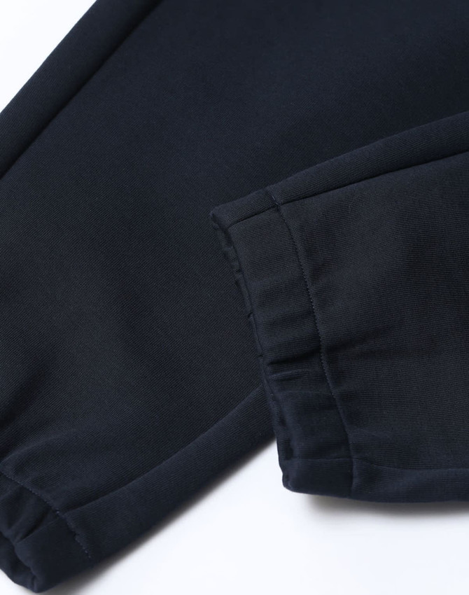Unisex airlayered CVC sweatpants in navy, featuring a cuffed hem and soft fabric texture. Complete with a logo.