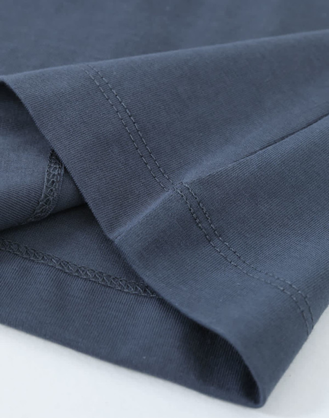 A close-up of a men's long-sleeve tee shirt in dark navy cotton, highlighting the fabric and stitching details.