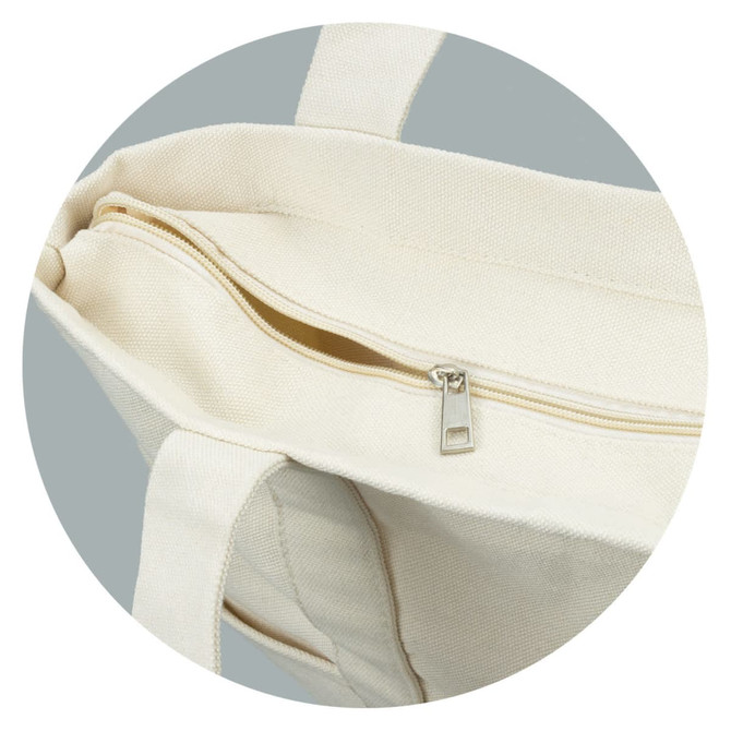 A cream-coloured canvas tote bag with a zipped compartment and sturdy handles. It features a subtle logo.