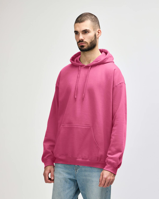 A pink Gildan Softstyle adult hooded sweatshirt displayed on a model. The sweatshirt features a front pocket and a hood.