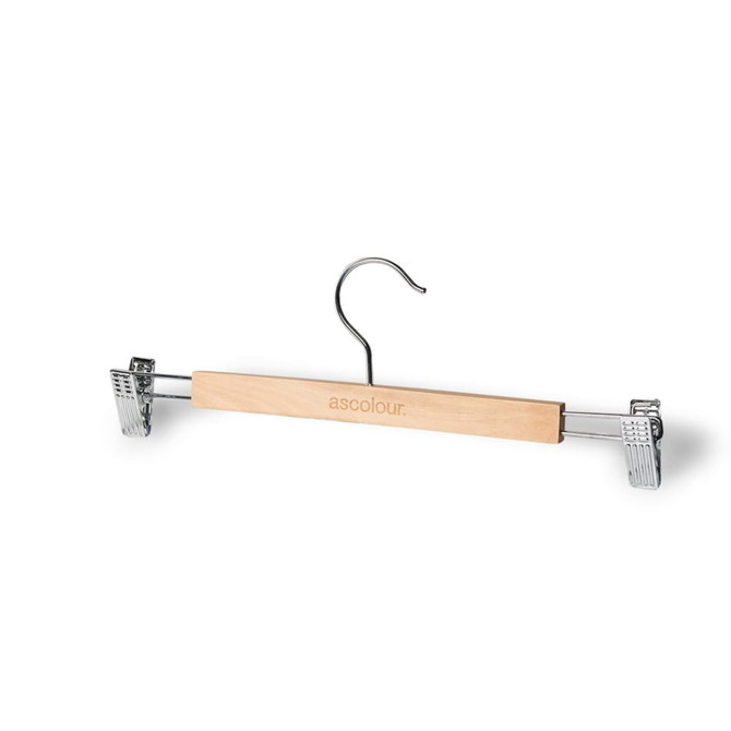 A wooden clip hanger in natural colour with chrome clips and a hook. It features a logo on the wooden bar.