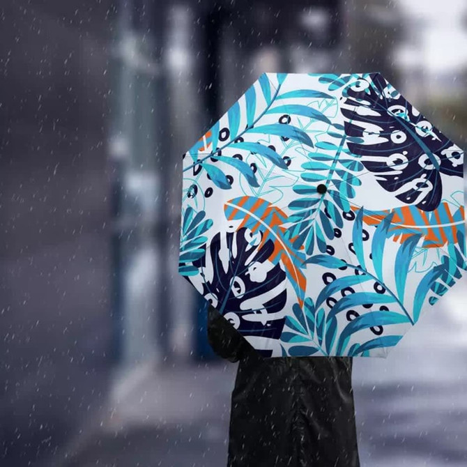 A full-colour umbrella featuring a tropical design with blue, green, and orange patterns against a white background.