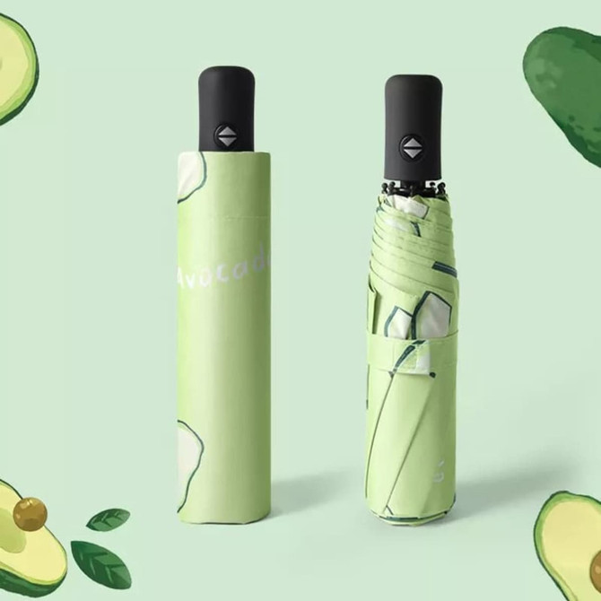 A green umbrella featuring an avocado design, neatly folded and compact. It includes a handle and has branding.