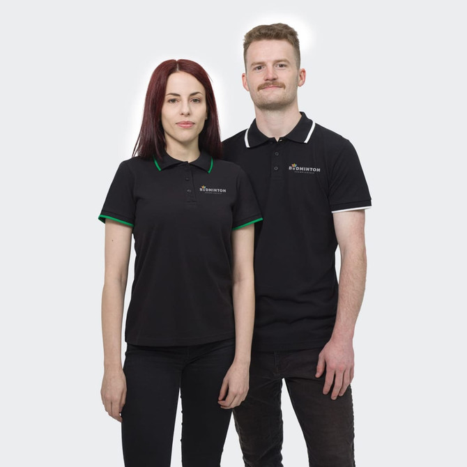 A black polo shirt featuring contrasting green and white collar details, worn by two models. The shirt has a logo.