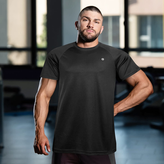 A black Swiss Peak Urban T-Shirt displayed on a model in a fitness environment, featuring a logo.