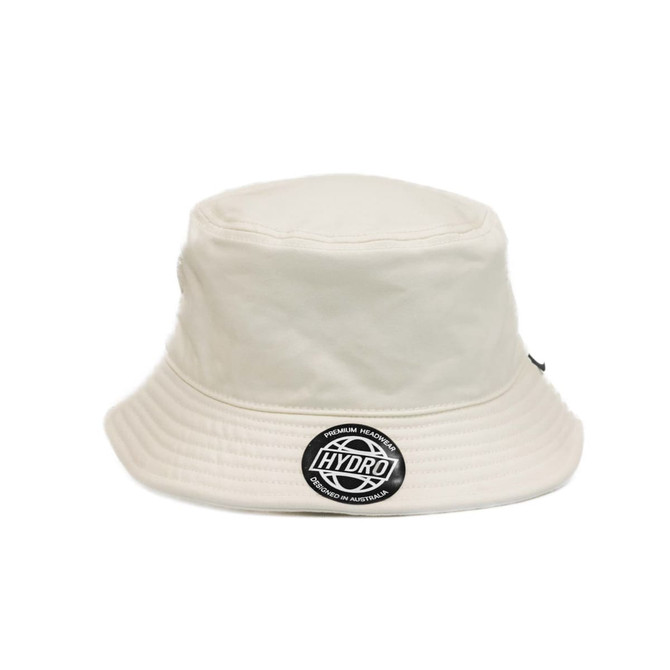 A cream bucket hat featuring a round logo on the front. It has a wide brim and a structured design.