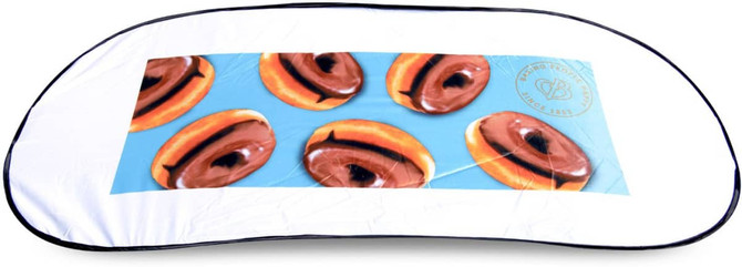 A foldable car sun visor featuring a design of chocolate-covered donuts on a light blue background with a black trim.
