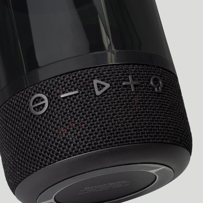 A black Bluetooth speaker with textured fabric and control buttons on the side, featuring a sleek design and a logo.