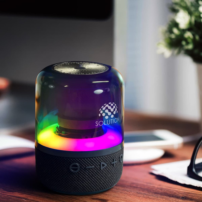 A Bluetooth speaker with a rainbow-lit base and a sleek, rounded design, featuring a logo and button controls.