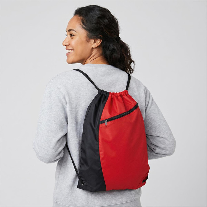 A drawstring bag in red and black, worn on the back by a person, featuring a zipped pocket and adjustable straps.