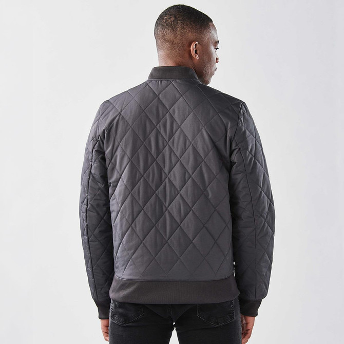A men's thermal jacket in dark grey with a quilted design and ribbed cuffs. It features a branding logo.