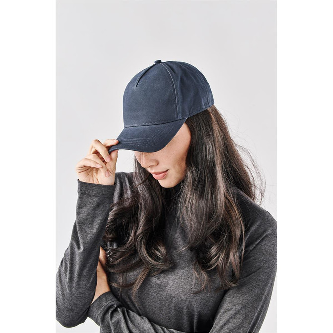 A navy Explorer Cap displayed on a model with long hair, featuring a simple design and a logo.