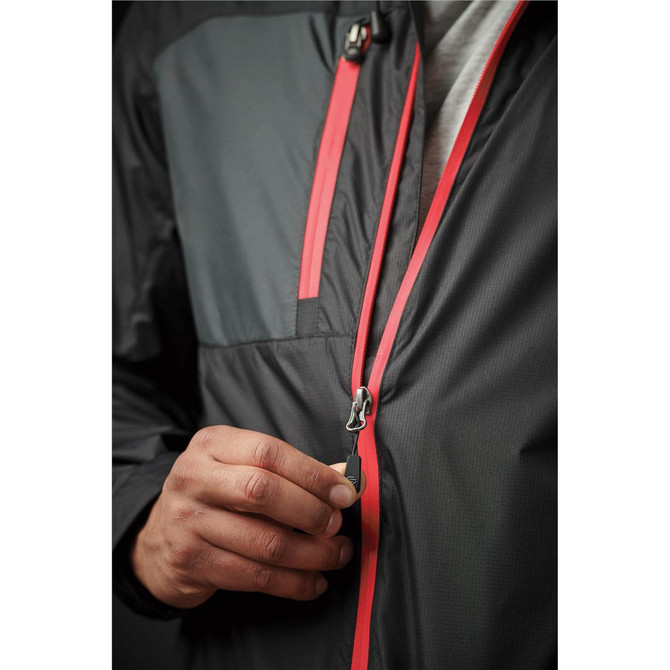 A person zips up a black rain jacket featuring red accents and a logo on the front.