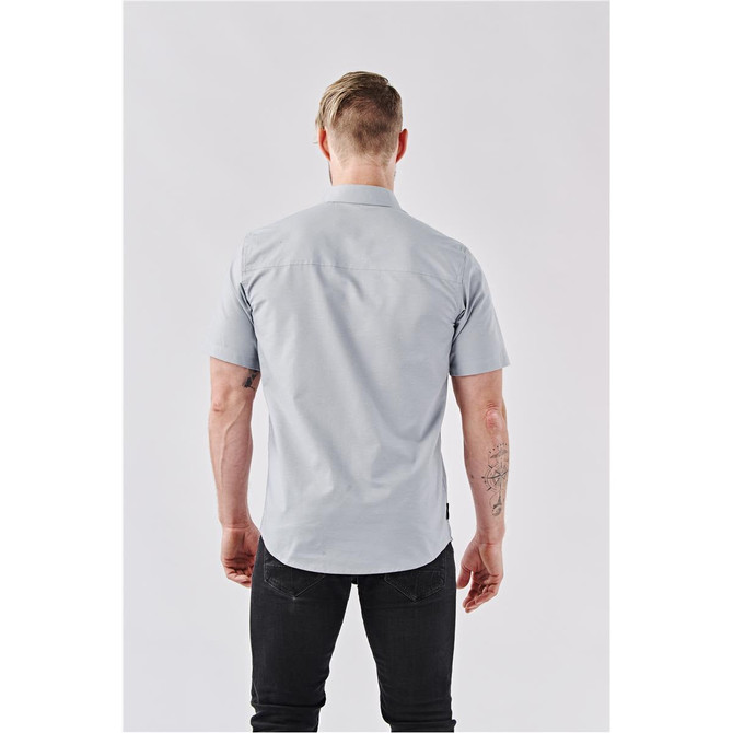 A light blue short-sleeved button-up shirt viewed from the back, featuring visible stitching and a logo label.