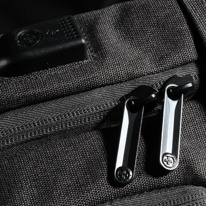 A close-up of a black Swissdigital Arosa Backpack featuring sturdy zippers and a logo on the fabric.