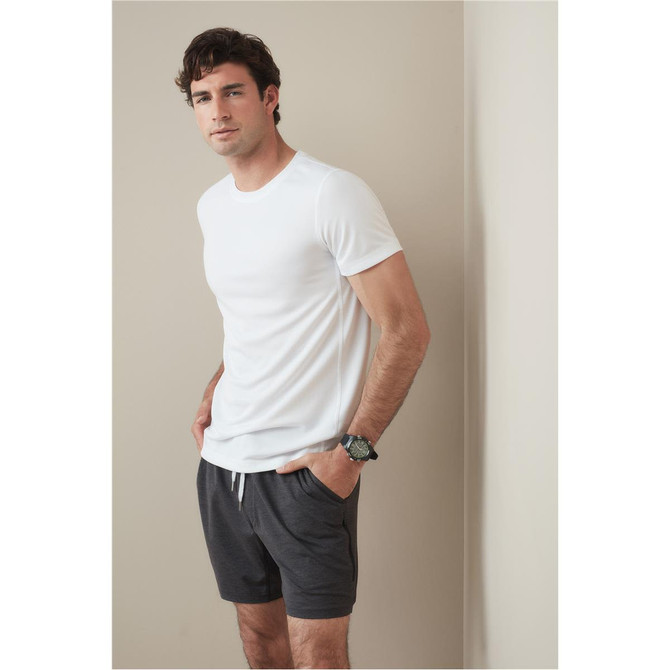 A white crew neck t-shirt displayed on a model, paired with grey shorts. The shirt features a logo.