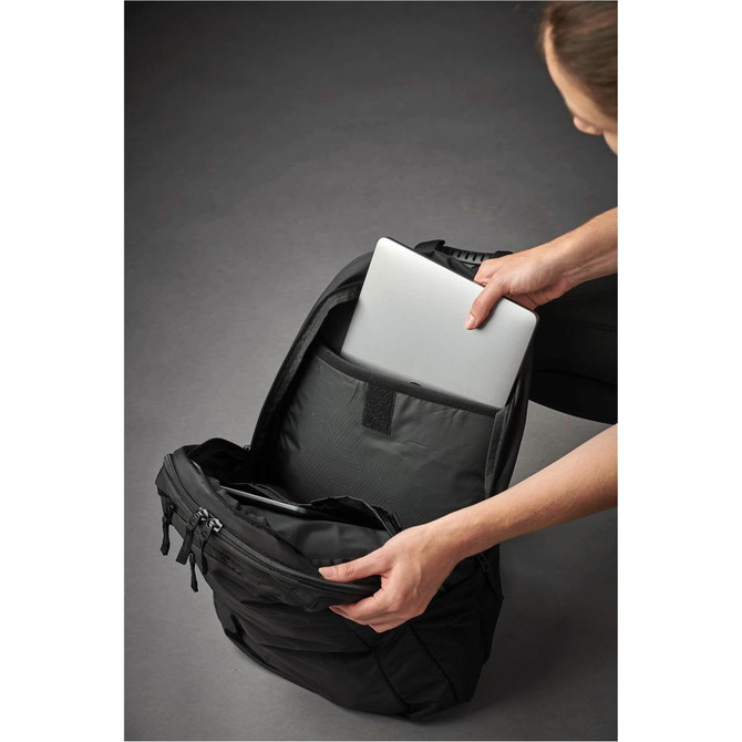A laptop bag in black being opened to reveal a silver laptop inside. The bag has multiple compartments.