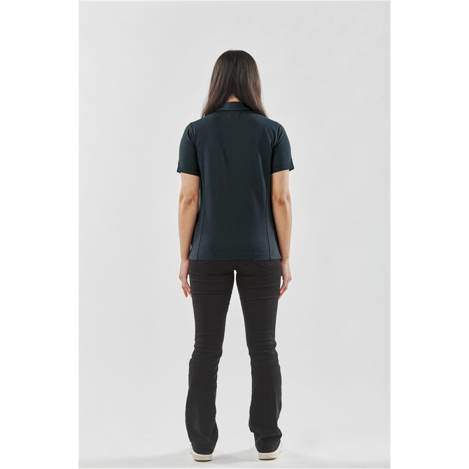 A woman wearing a black polo shirt stands with her back to the viewer, paired with black pants. The shirt has a logo.