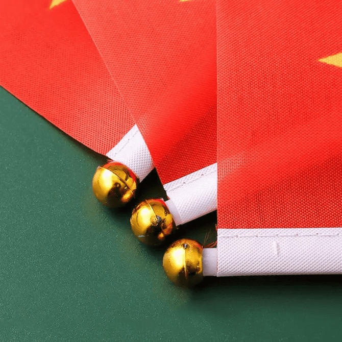 A red polyester handheld flag with a pole adorned with golden balls at the ends.