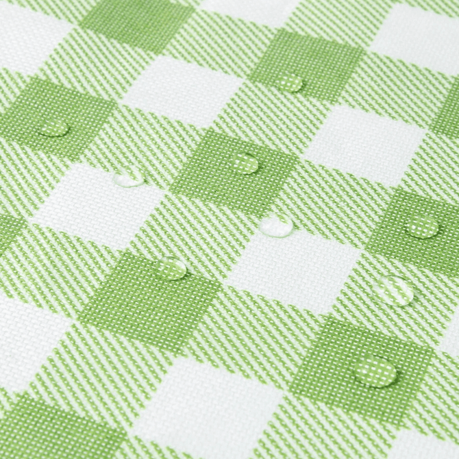 A green and white checkered picnic blanket with water droplets on the surface, featuring a textured fabric design.
