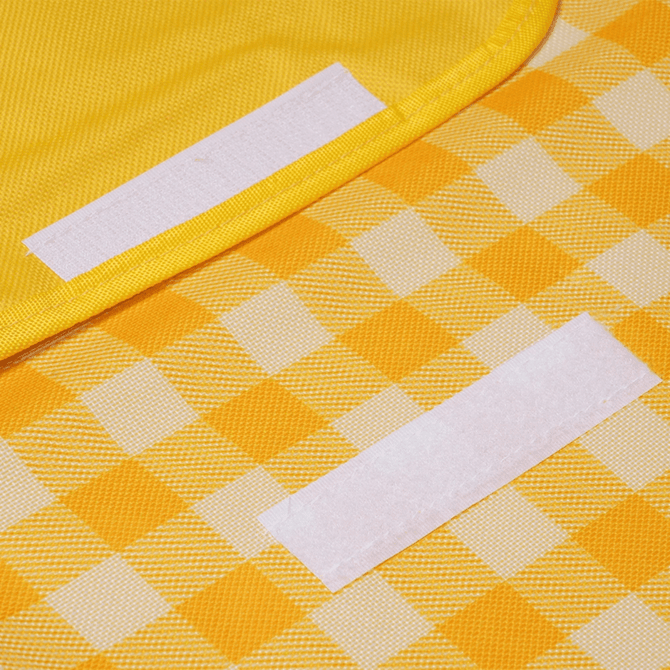 A yellow checkered picnic blanket featuring soft fabric and Velcro strips for secure fastening.