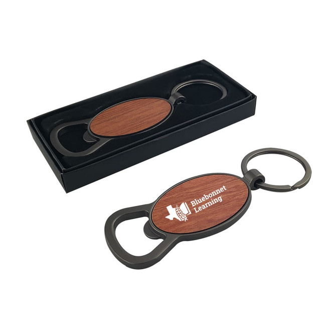 A drink bottle opener in round shape with a wooden finish and a black metal keyring, presented in a sleek box.