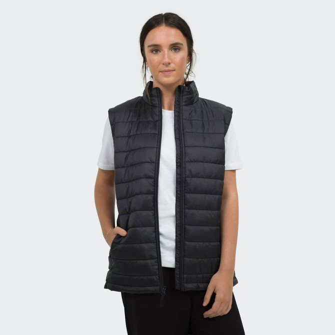 A woman is wearing a black puffer vest over a white t-shirt, featuring a logo and zip-up design.