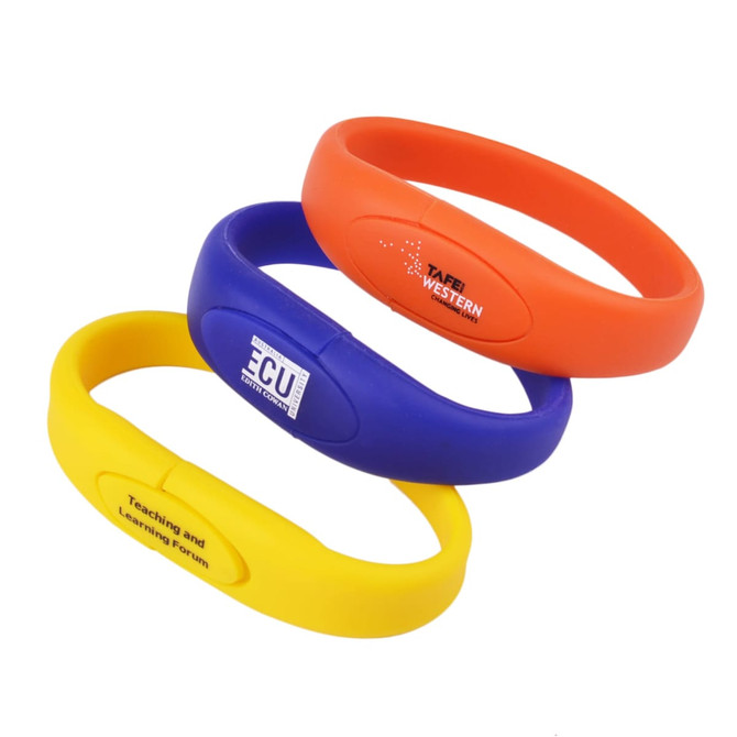 Three oval silicone wristband flash drives in orange, blue, and yellow, featuring logos on their surfaces.