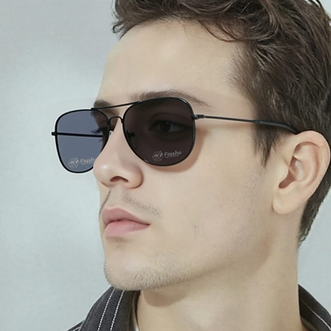 Classic aviator sunglasses with a black frame and dark lenses, displayed on a male model.