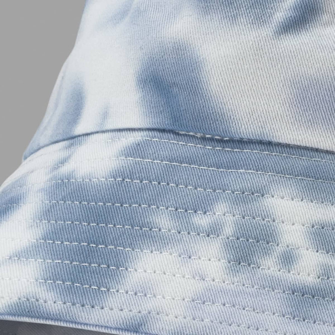 A blue and white tie dye bucket hat featuring stitched detailing and a logo.