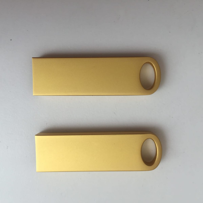 A pair of gold flash drives with a smooth, matte finish and a hole for attachment.
