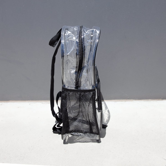 A clear stadium backpack in transparent PVC with black straps and a mesh pocket at the bottom.