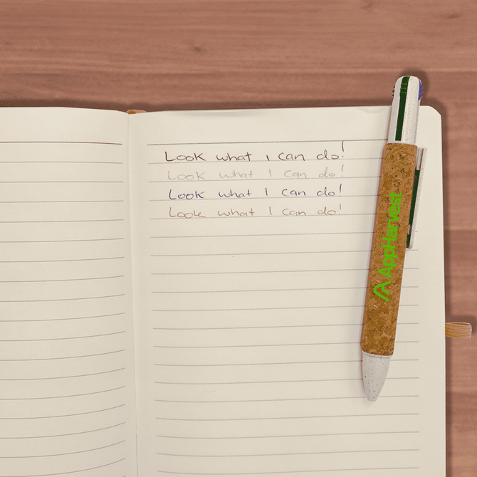 A cork pen with a green clip resting on an open lined notebook with handwritten notes.
