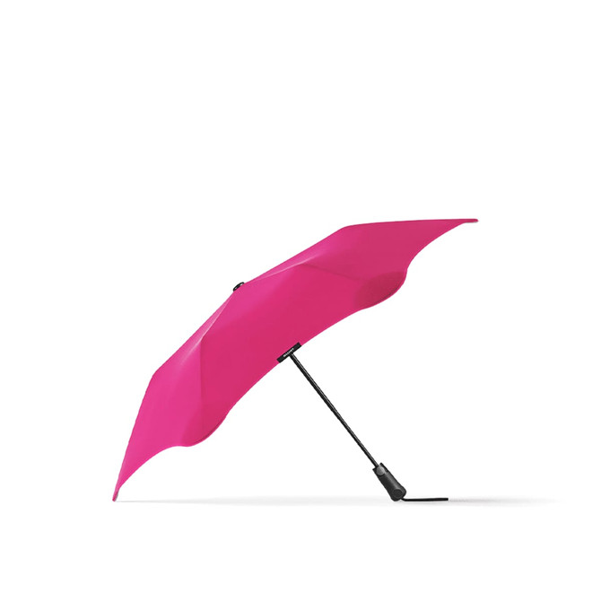 A bright pink BLUNT Metro Umbrella with a sleek black handle and a unique design.