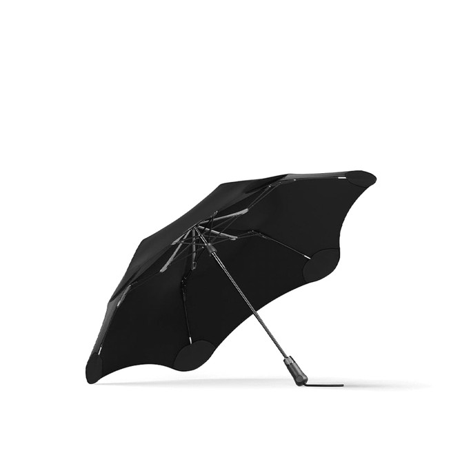 A black umbrella with a sleek design featuring a logo, opened and resting on a flat surface.