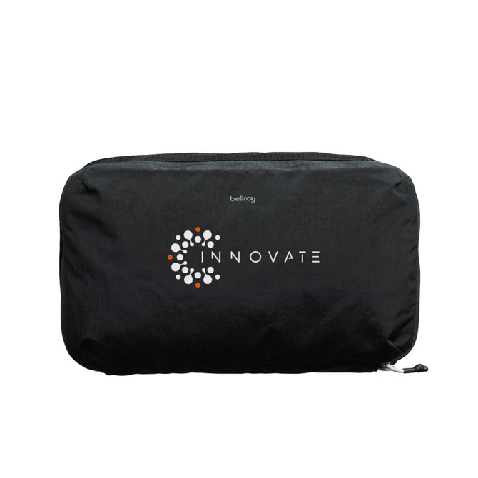 A black packing cube featuring a circular logo, designed for organising travel essentials.