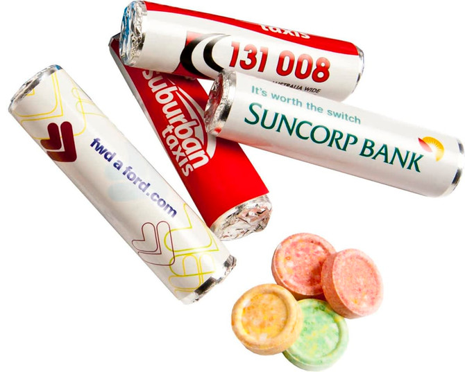 A selection of colourful round lollies beside multiple rolls of branded confectionery wrappers in red and white.