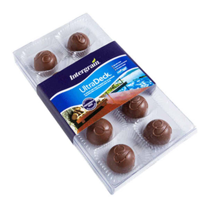 A chocolate box featuring round, milk chocolate pieces arranged in a clear plastic tray, with a branded sleeve.