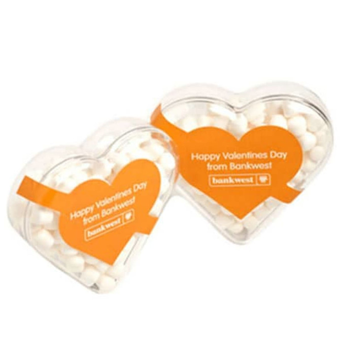 Acrylic heart-shaped container filled with white mints, featuring an orange band and a logo.