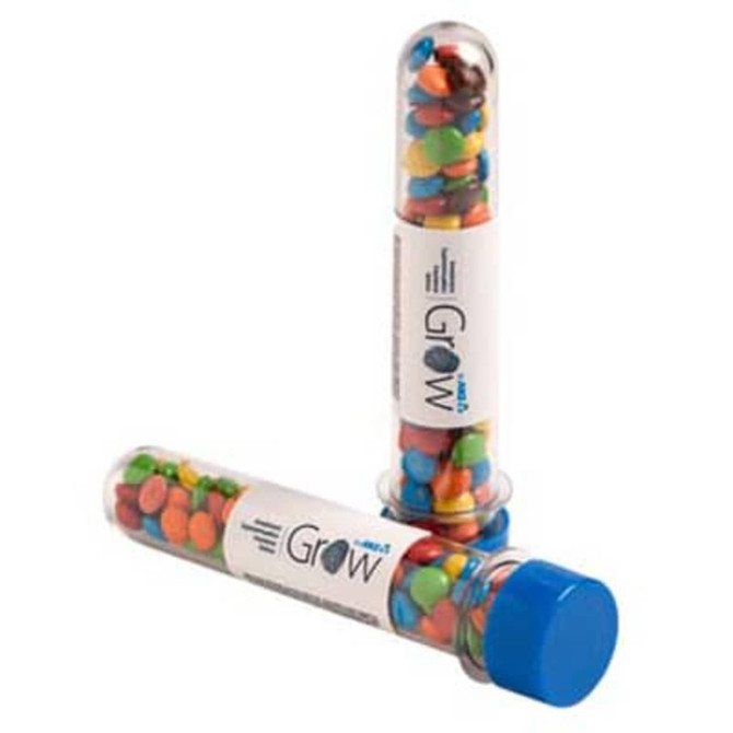 A promotional test tube filled with colourful M&Ms, featuring a blue cap and a branding label.